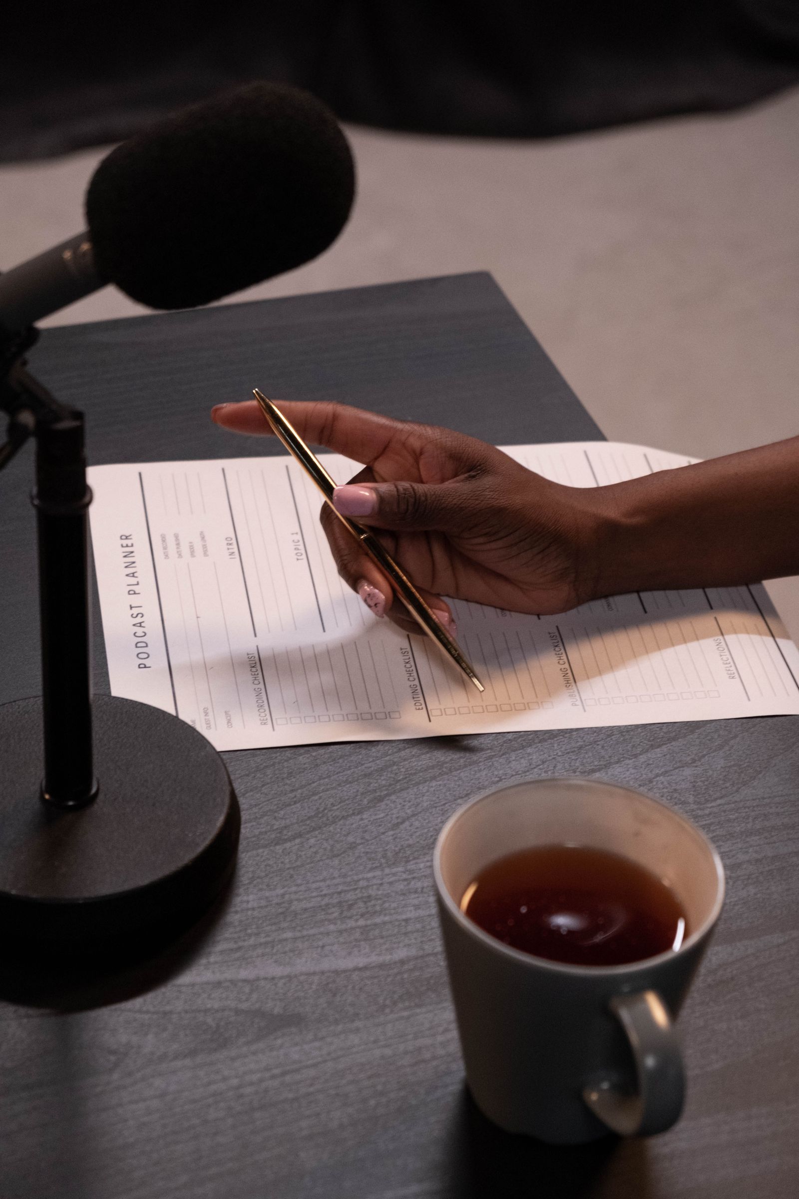 Production checklist pinned above a podcast recording setup